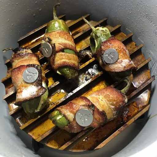 Photo of Place the SearNSizzle™ in the middle position and arrange the poppers on the rails. Cook the poppers on AirCrisp at 340F for 20 minutes checking to make sure the bacon hits your desired doneness.